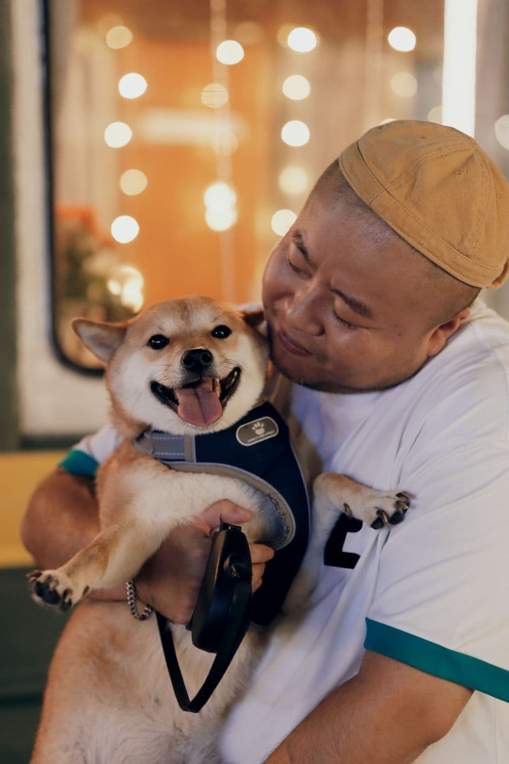 A man holding his shiba inu cheek to cheek